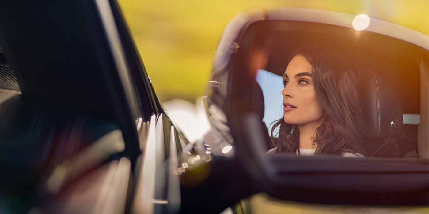 Bentley Brisbane profile of dark haired woman's face in mirror of Bentley car in sunlight