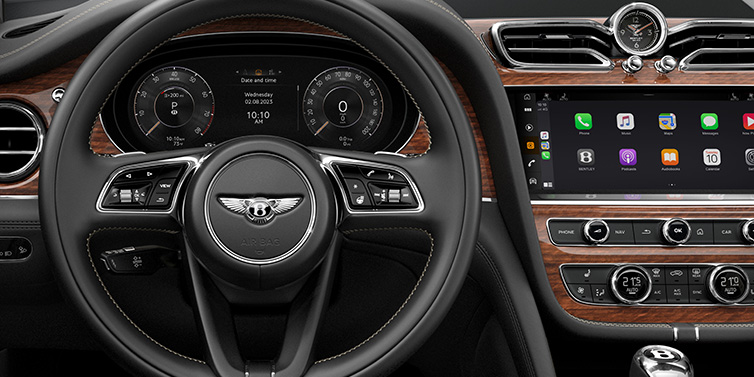 Bentley Brisbane Bentley Bentayga SUV front interior detail of steering wheel and driver screens surrounded by Beluga black hide and Crown Cut Walnut veneer