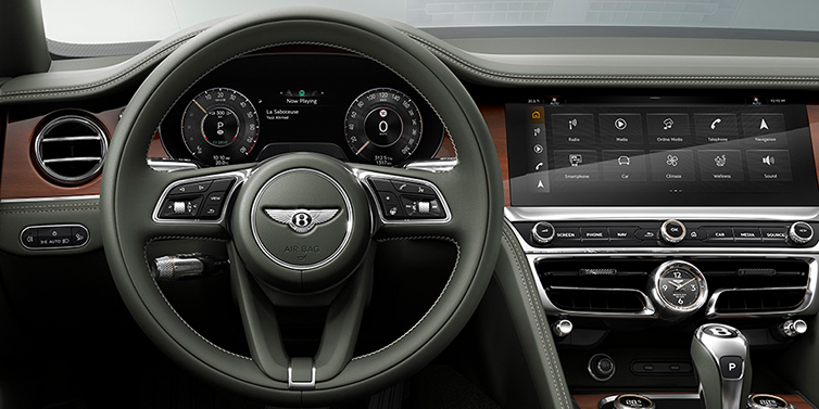 Bentley Brisbane New Bentley Flying Spur front cabin interior in Cumbrian green hide with Crown Cut walnut veneer showing steering wheel and driver controls