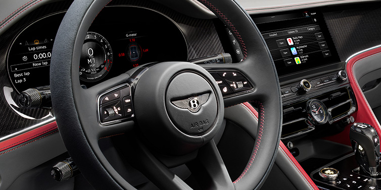 Bentley Brisbane Bentley Flying Spur Speed sedan front interior detail showing steering wheel and driver screens surrounded with Hotspur red and Gravity Grey hides